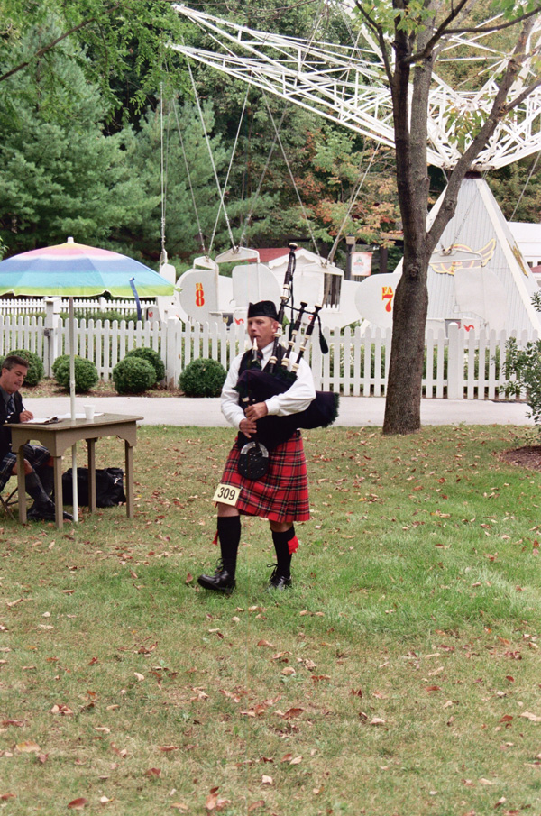Bagpiper Paul Cora piping music on his bagpipes at a bagpiping competition